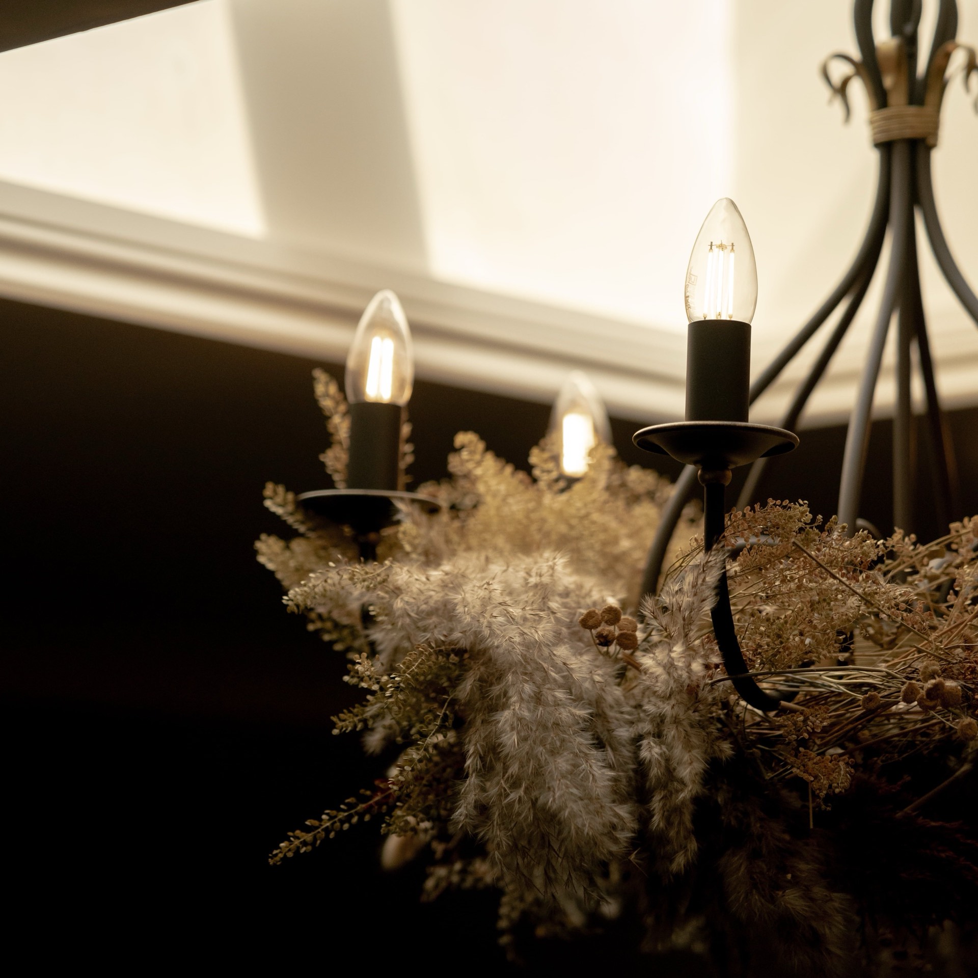 A dried flower arrangement beneath the chandelier at Mason's