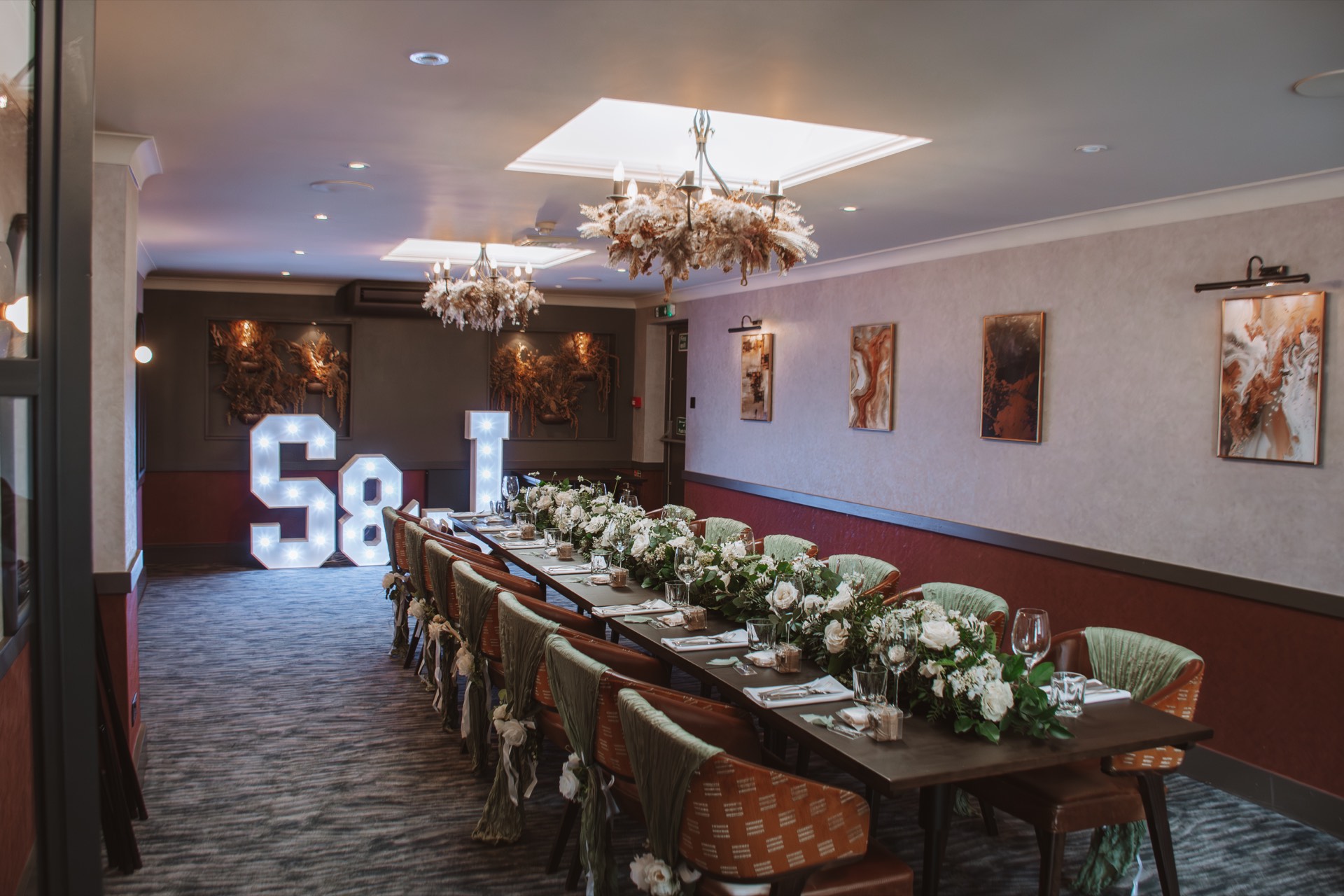 An elegant banquet table with floral arrangements and light-up letters at Mason's