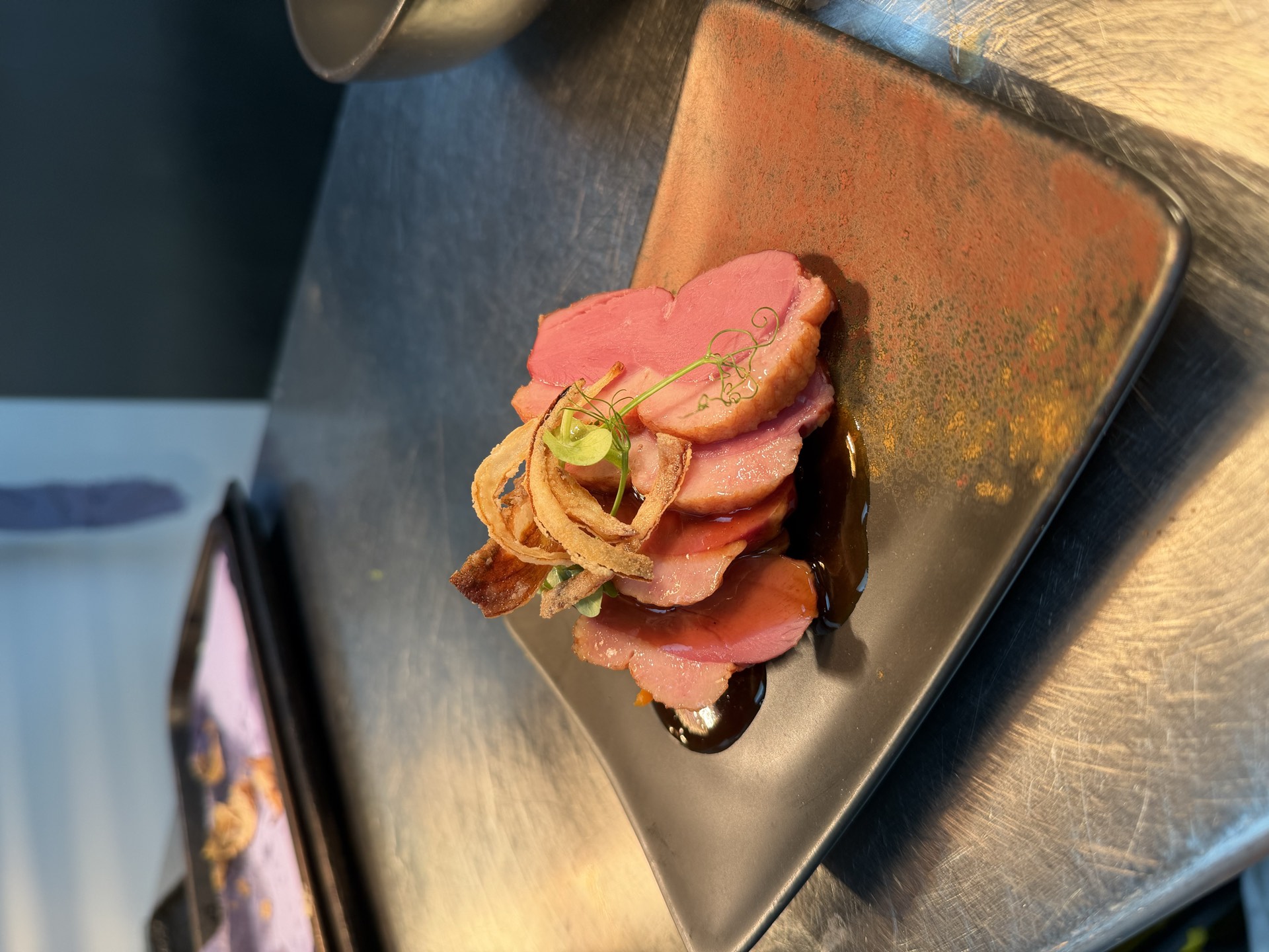 Sliced duck breast plated with a herb crust at Mason's